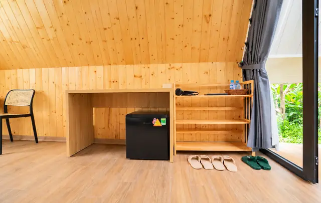 Góc tiện nghi trong bungalow mái chữ A: kệ gỗ thông, tủ lạnh mini, dép đi trong phòng